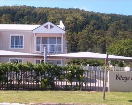 Pink and white two-story holiday home with landscaped garden and white fence