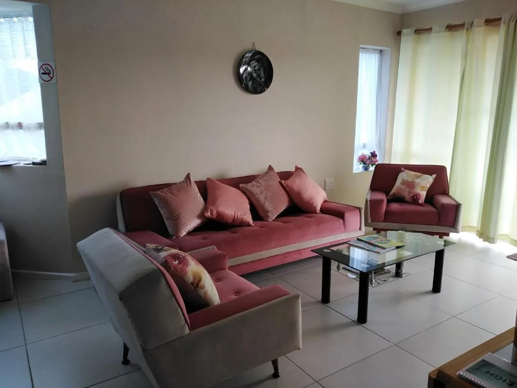 Spacious living room with burgundy sofas and armchair, glass coffee table