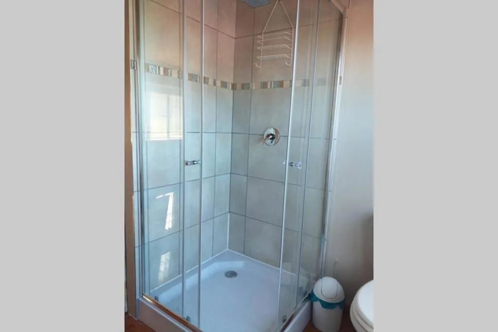 Modern glass shower enclosure with tiled walls and white base tray