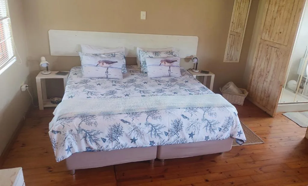 Spacious bedroom with double bed and coastal-themed bedding decor