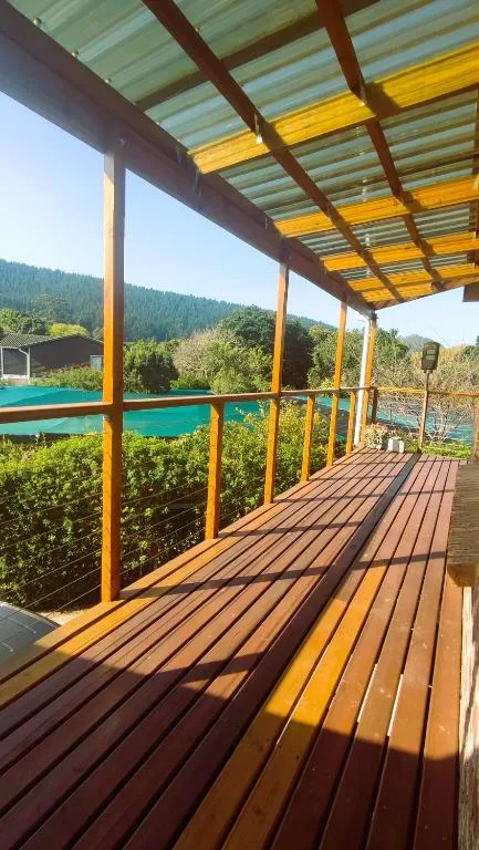Wooden deck with pergola overlooking mountain views and turquoise water