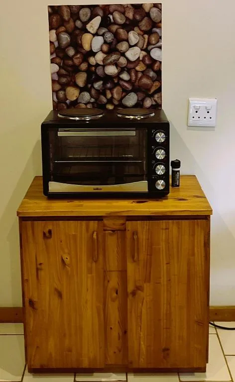 Black electric oven on wooden cabinet with decorative backsplash