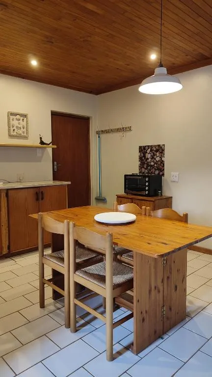 Wooden dining table with chairs in open-plan kitchen area