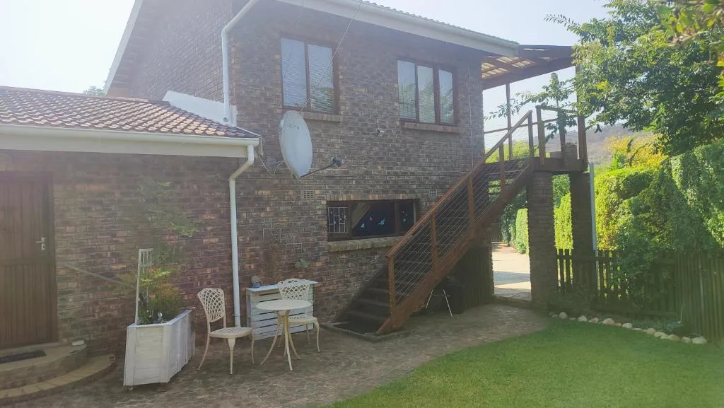 Brick holiday home with elevated deck stairs and garden seating area