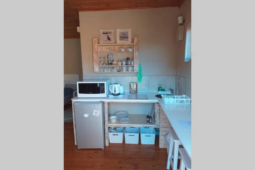 Compact kitchenette with refrigerator, microwave, cooktop, and storage