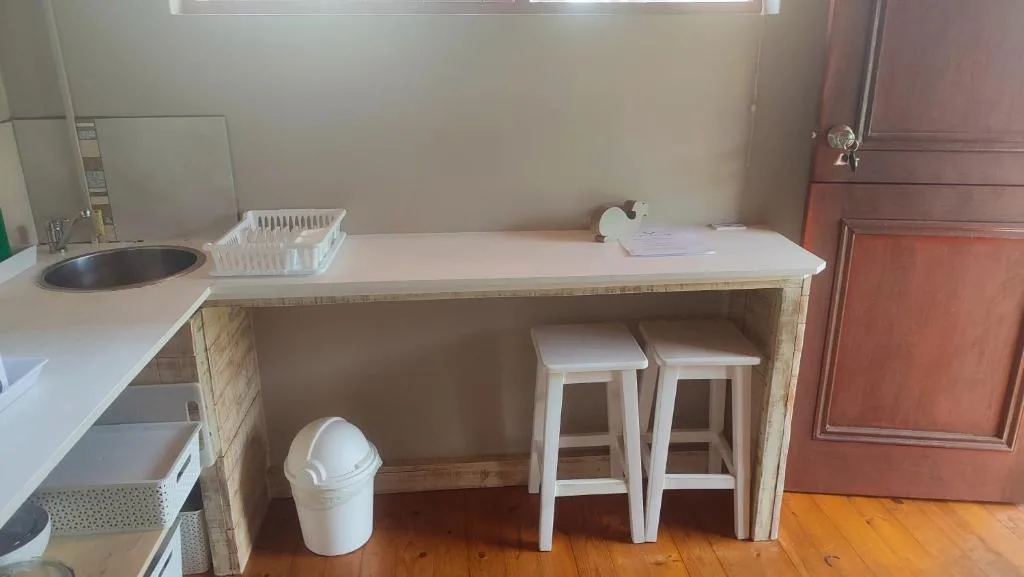 Compact kitchen with sink, counter space, and bar seating for two