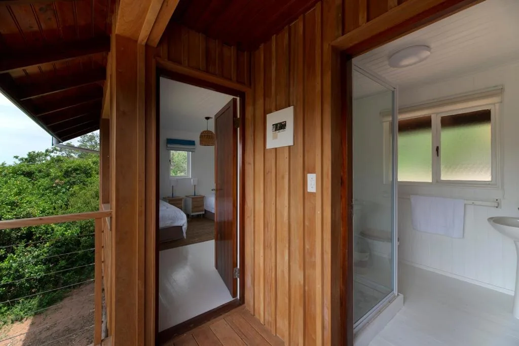 Modern wooden cabin interior with bedroom and bathroom access visible