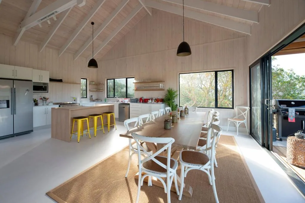 Open-plan kitchen and dining area with island seating and large windows