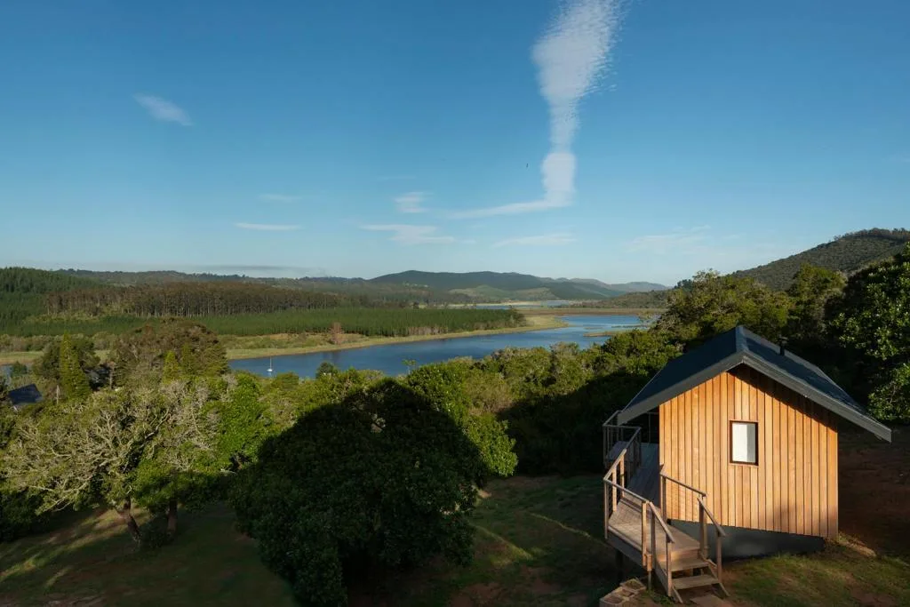 Scenic lagoon and forest landscape with mountains under blue sky