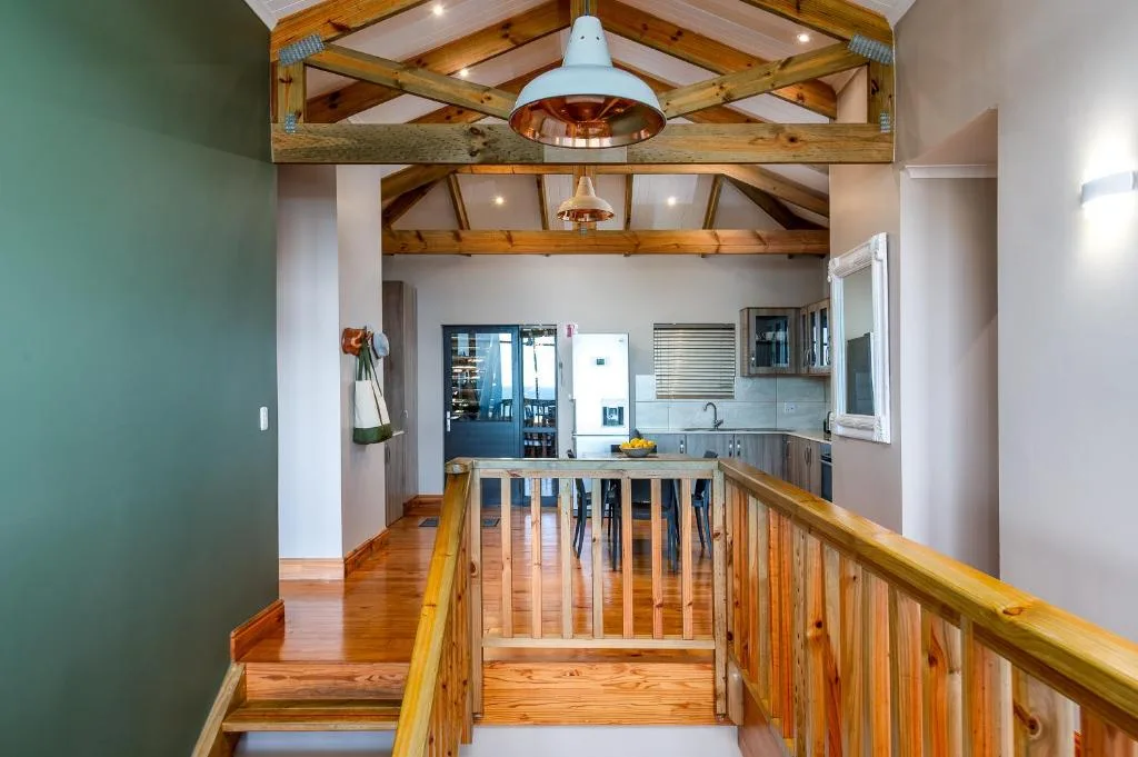 Open-plan kitchen with exposed wooden beams and pendant lighting