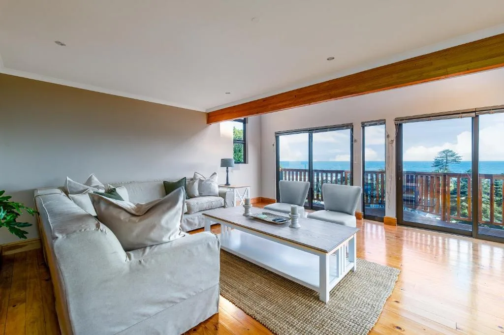 Spacious lounge with ocean views through large sliding glass doors and deck