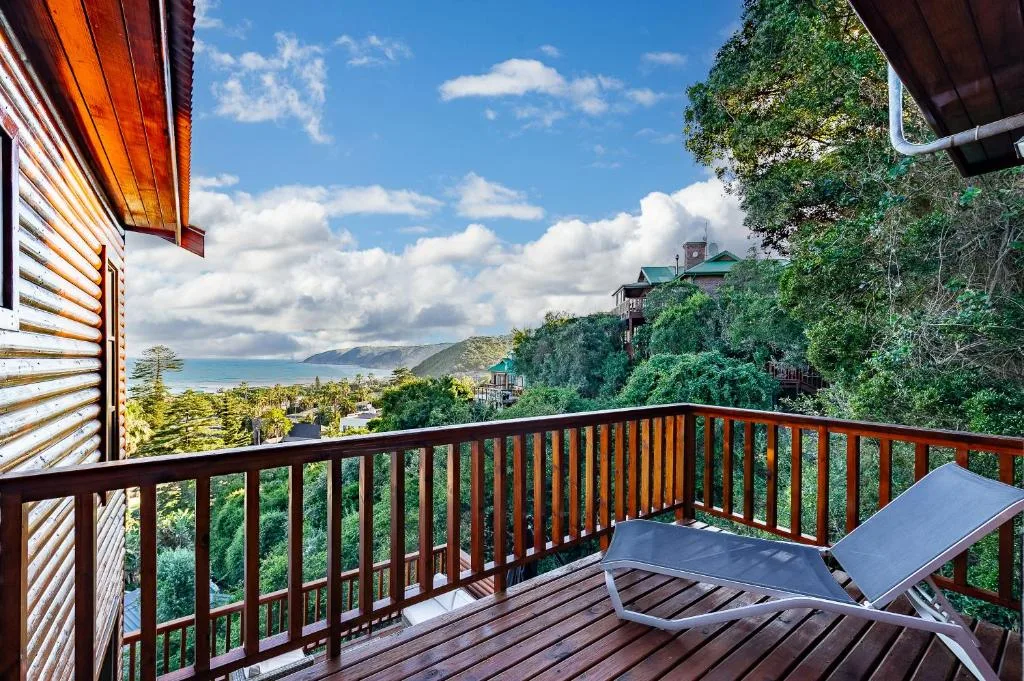 Coastal mountain landscape visible from private wooden deck with loungers