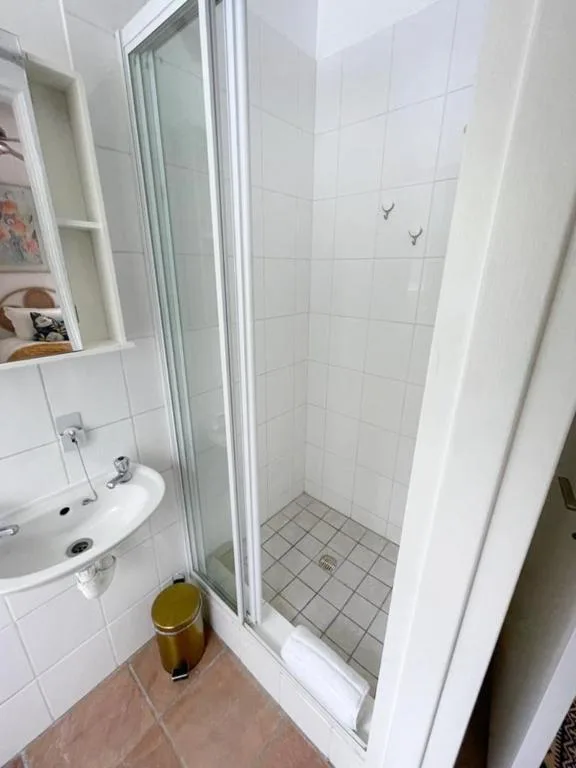 Clean white bathroom with shower enclosure and wall-mounted sink vanity