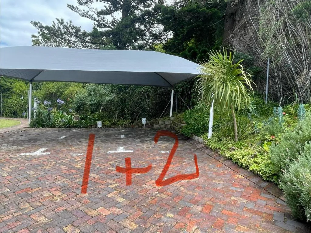 Shaded patio area with modern canopy and surrounding garden vegetation