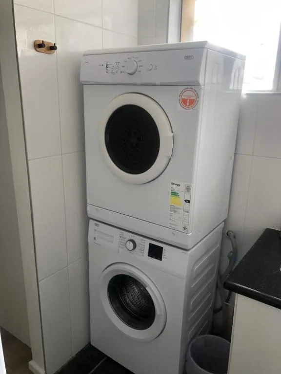 Stacked washing machine and dryer in white laundry room