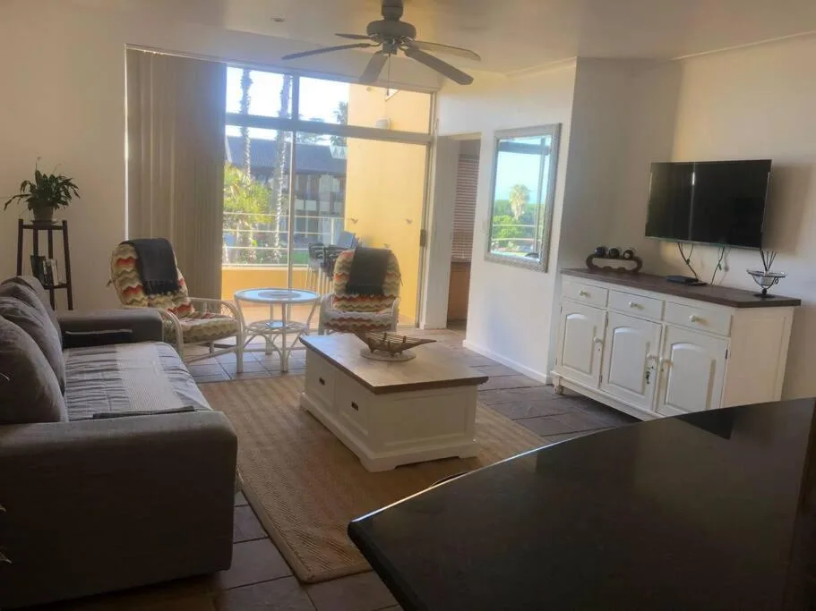 Spacious lounge with comfortable seating, TV, and glass doors opening to views