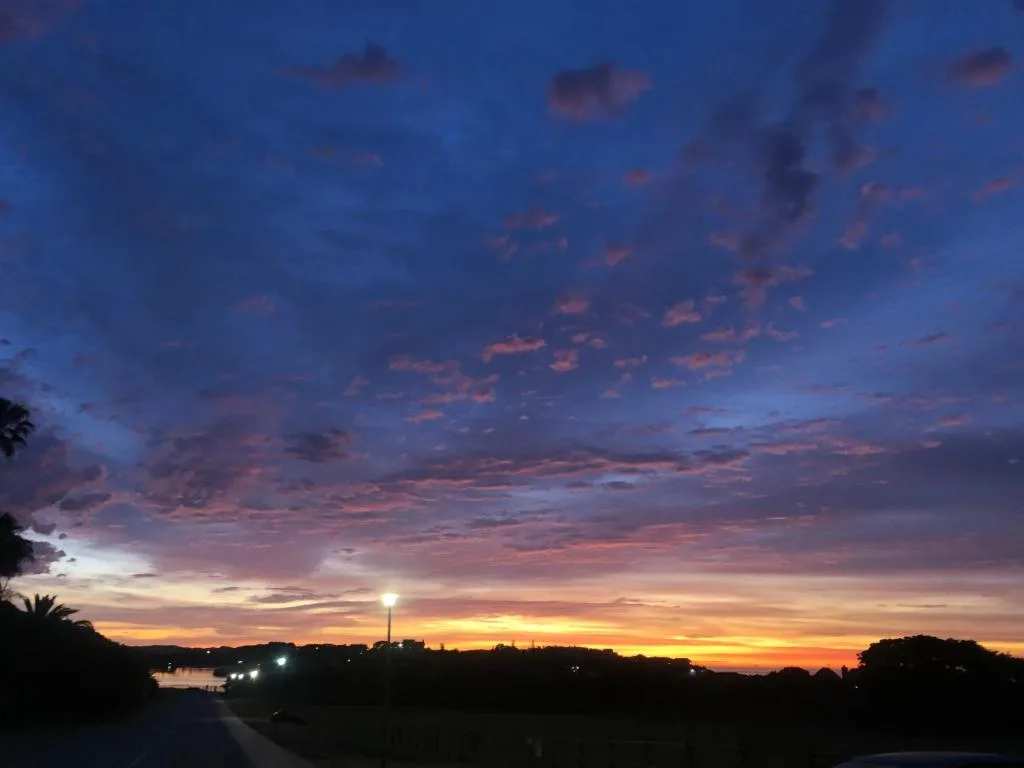 Stunning sunset over Wilderness lagoon with vibrant orange and blue sky