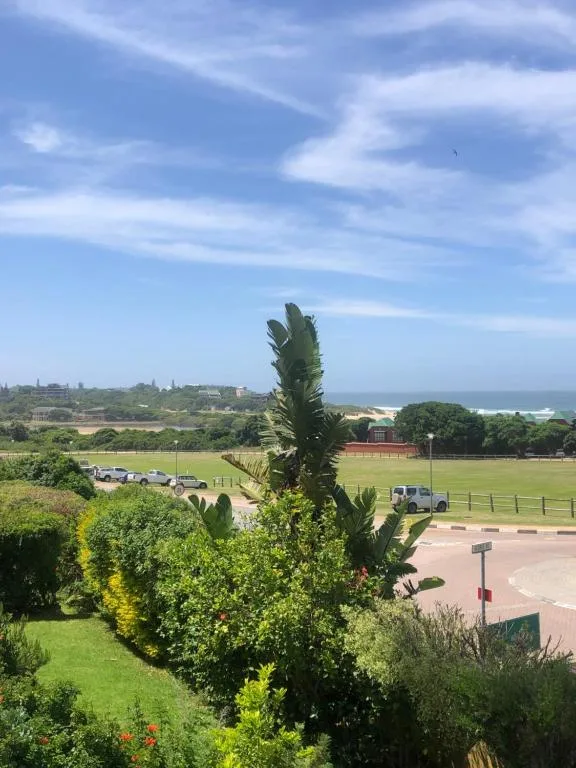Panoramic landscape view of Wilderness valley with green fields and distant ocean