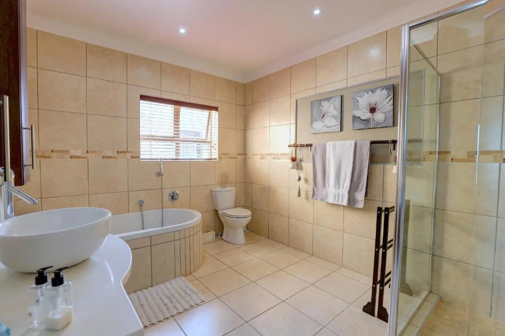 Spacious bathroom with freestanding tub, shower enclosure, and toilet
