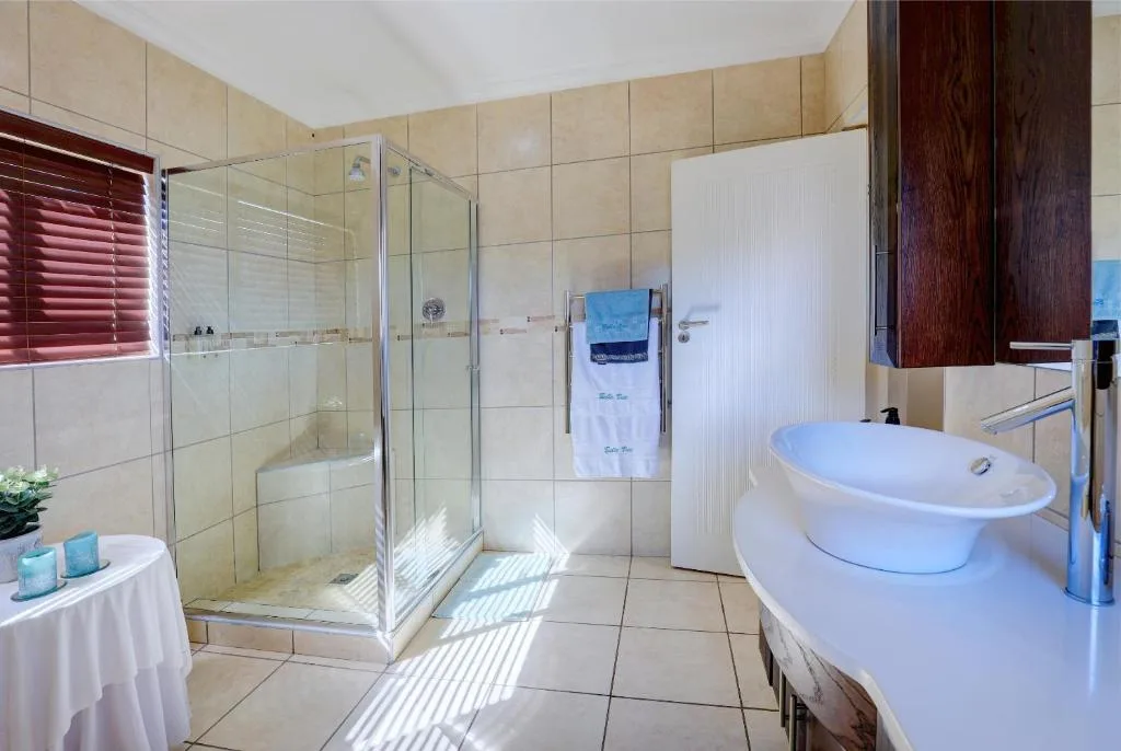 Modern bathroom with glass shower enclosure, freestanding tub, and vanity