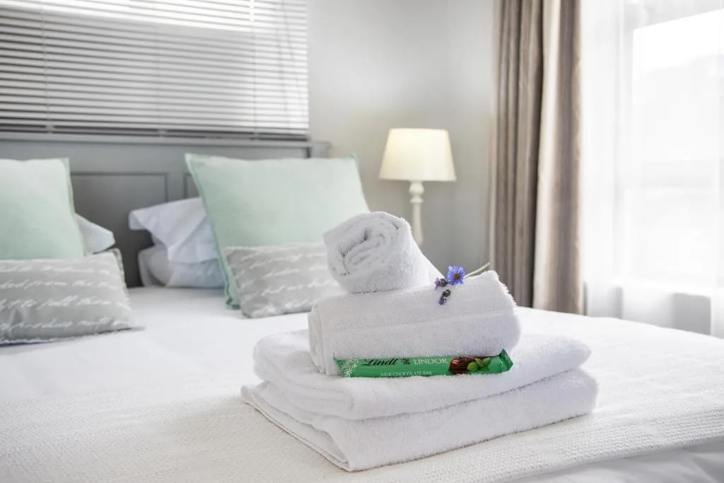 Bedroom with fresh towels and welcome chocolate on the bed