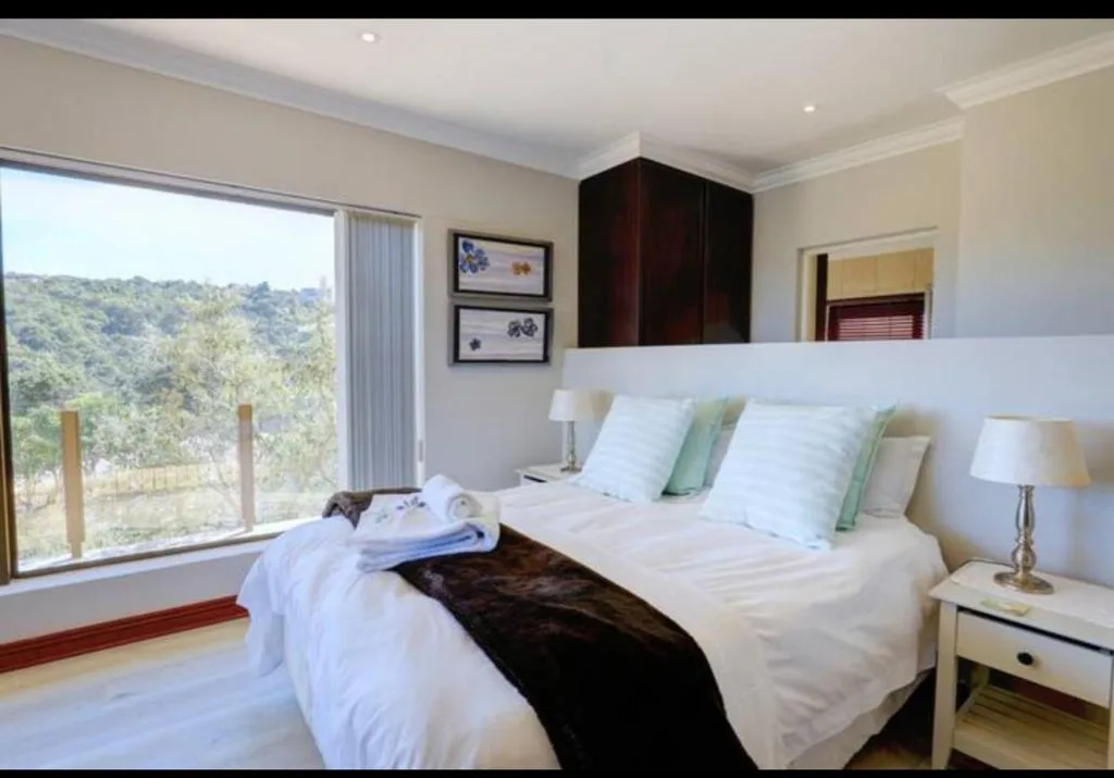 Bright bedroom with twin beds, mountain view through large windows