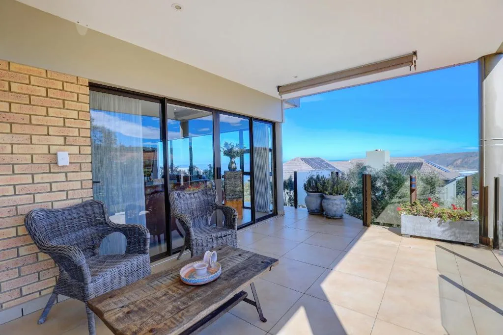 Spacious outdoor patio with wicker seating and panoramic mountain views