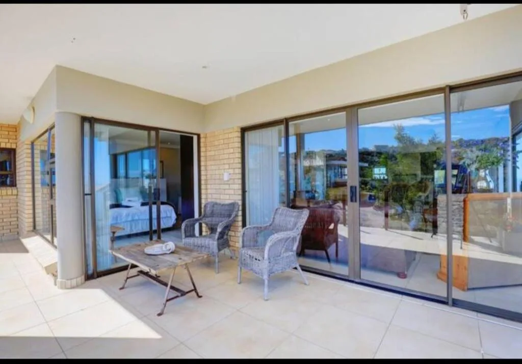 Spacious patio with outdoor seating and sliding glass doors opening to bedroom