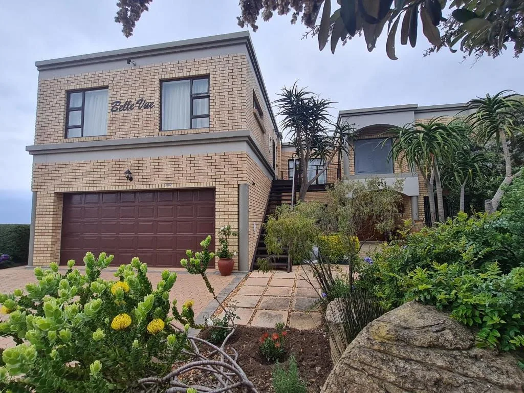 Modern brick home with garage, landscaped garden, and entry stairs