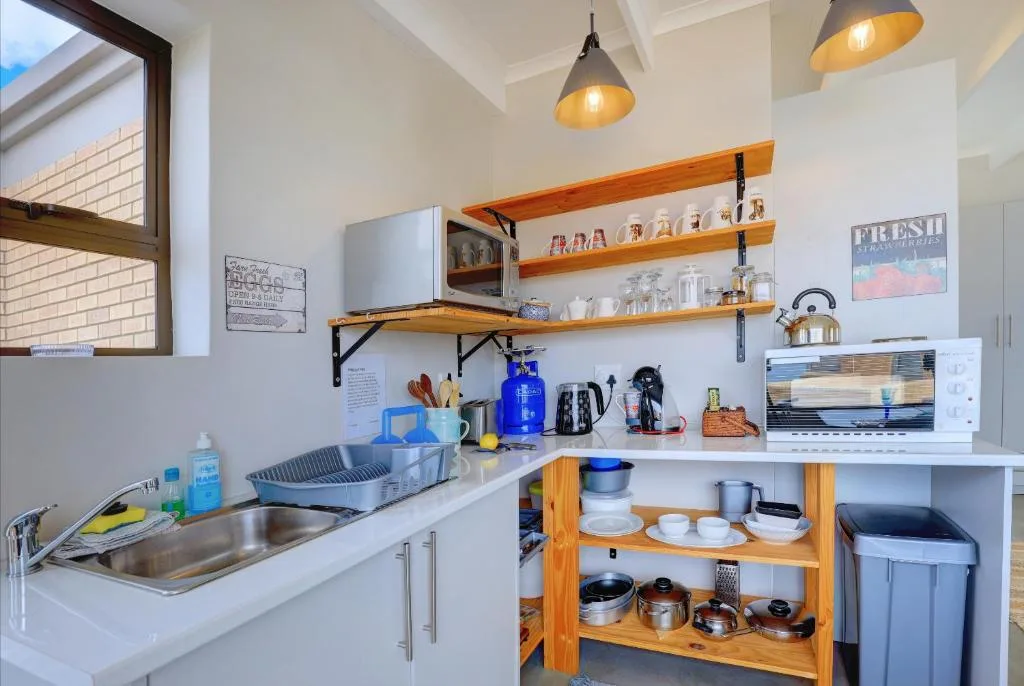 Modern kitchen with stainless steel sink, wooden shelves, and pendant lighting