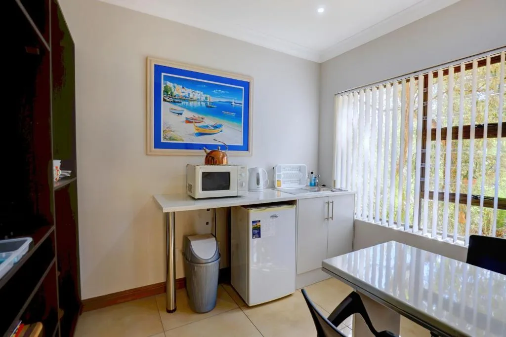 Compact kitchenette with microwave, fridge, and counter space