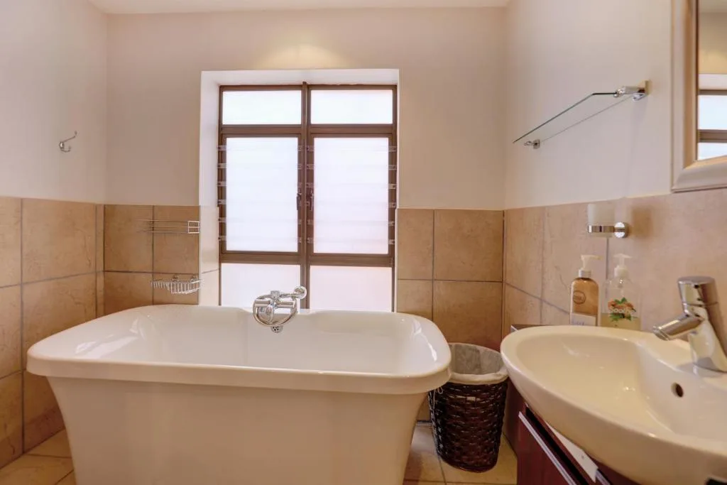 Spacious bathroom with freestanding tub and round sink vanity