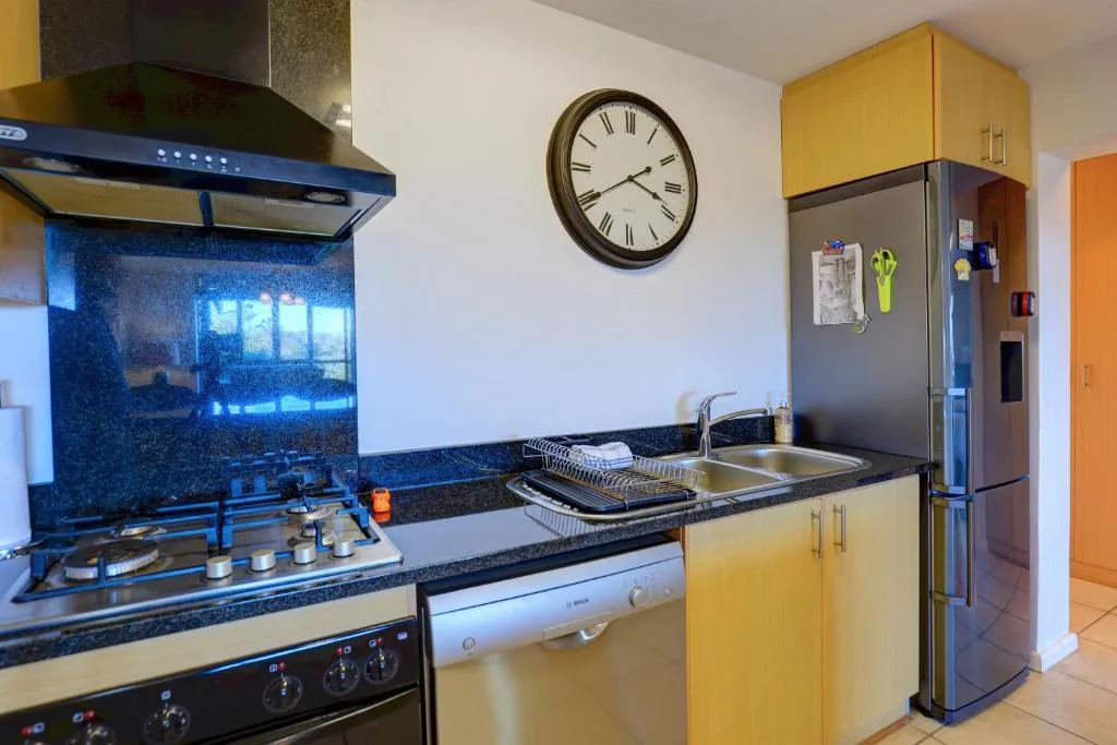 Modern kitchen with yellow cabinetry, gas stove, and stainless steel appliances