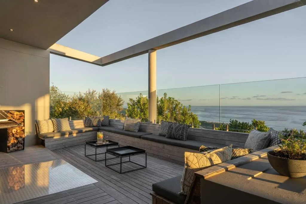 Spacious covered deck with ocean views, built-in seating, and potted plants