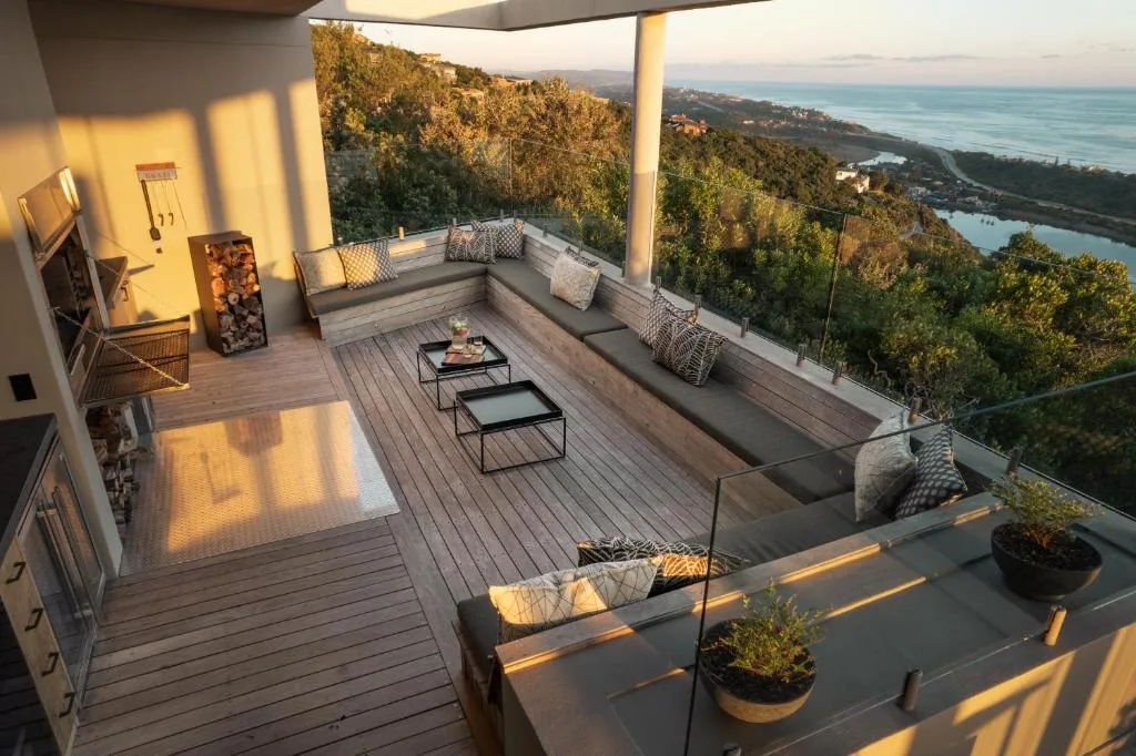 Elevated outdoor deck with seating, ocean and lagoon views at sunset