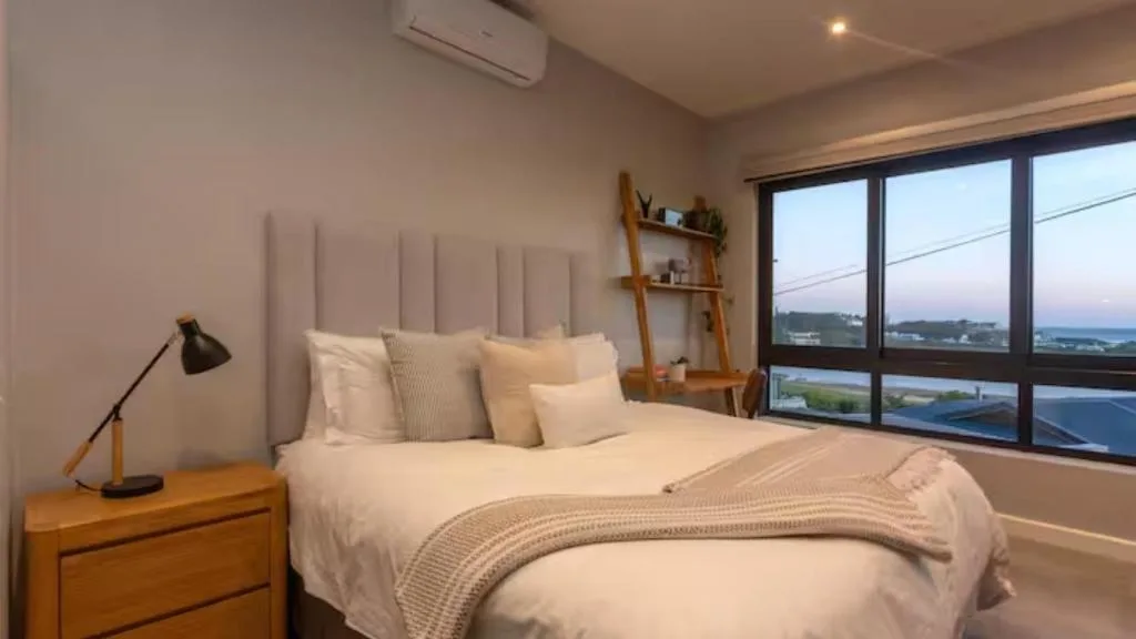 Modern bedroom with ocean and lagoon views through large windows