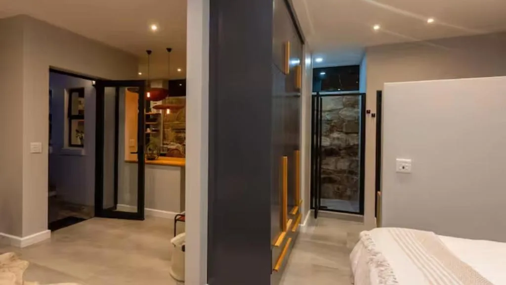 Modern bedroom with en-suite bathroom and glass shower enclosure visible