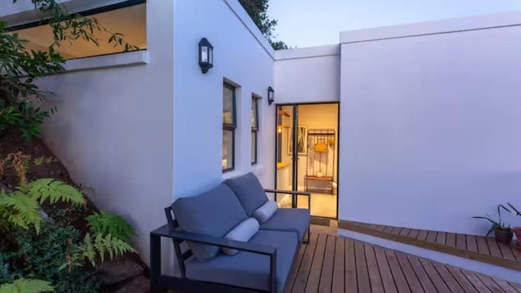 Modern wooden deck with outdoor seating facing contemporary white building