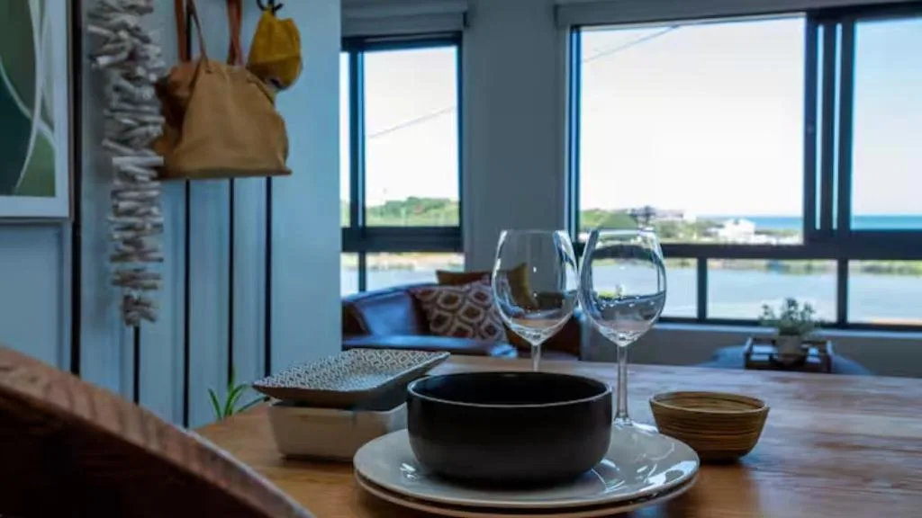Dining table with place setting and wine glasses overlooking coastal lagoon views