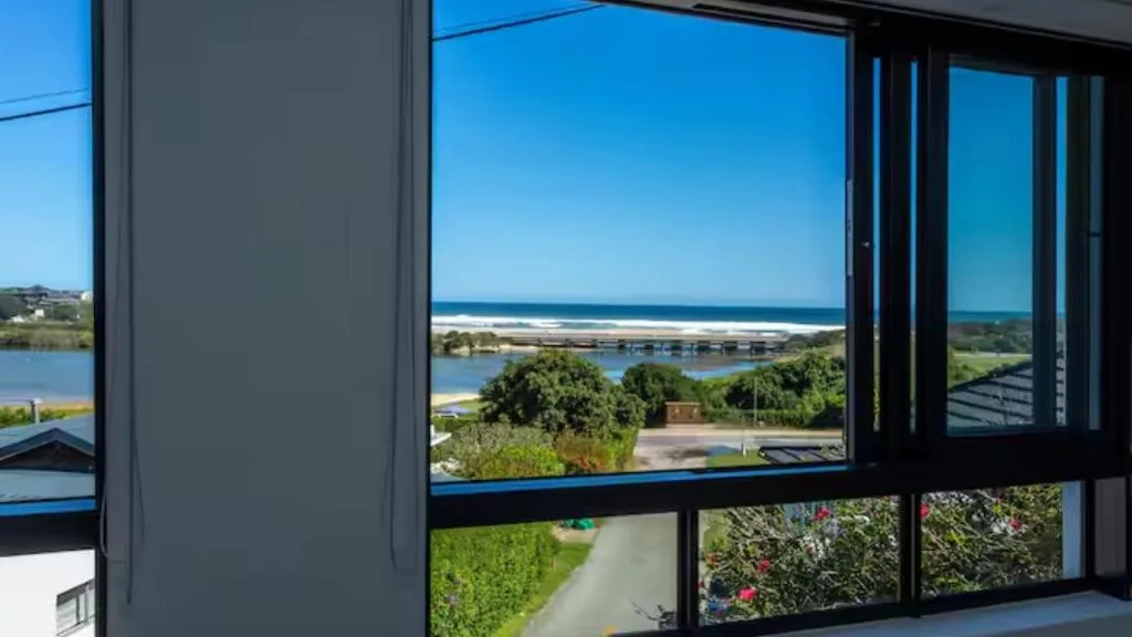 Expansive coastal and lagoon views through large modern windows from interior