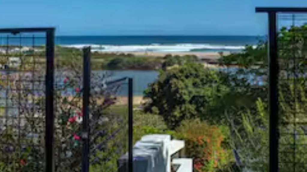 Ocean, beach, and lagoon vista framed by modern deck railings