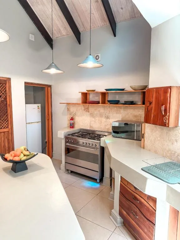 Modern kitchen with stainless steel stove, wooden cabinetry, and pendant lighting