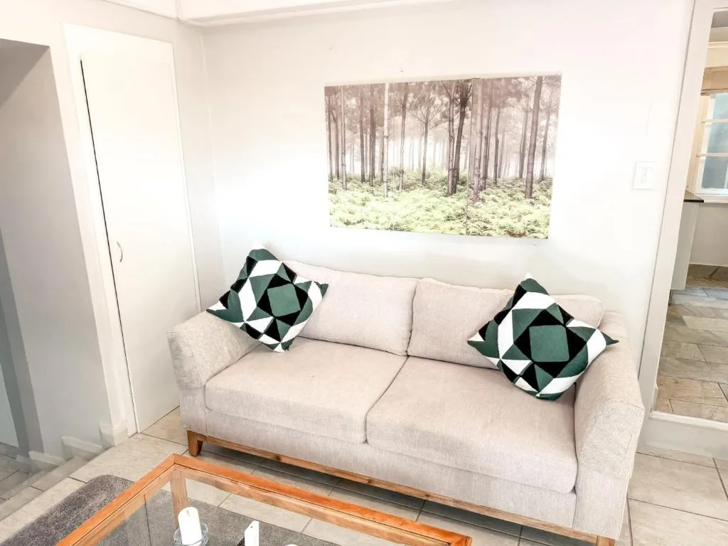 Cream upholstered sofa with geometric patterned cushions in bright living room