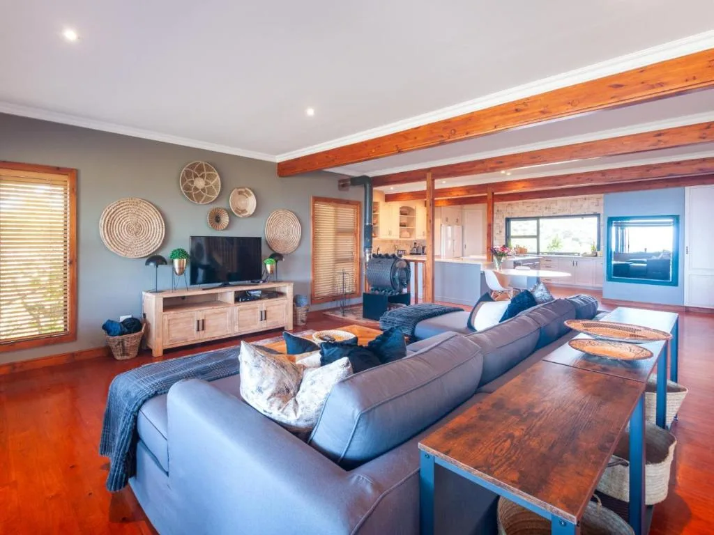 Spacious living room with gray sofa, wooden beams, and ocean views