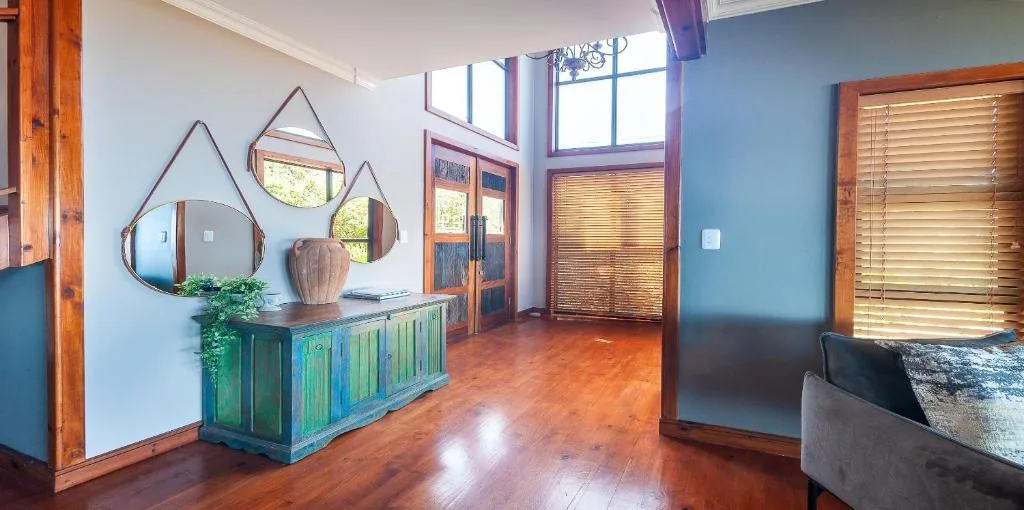 Modern lounge with blue accent walls, decorative mirrors, and wooden furnishings