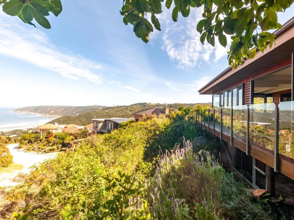 Coastal cliffs and beach vista from property deck with native vegetation