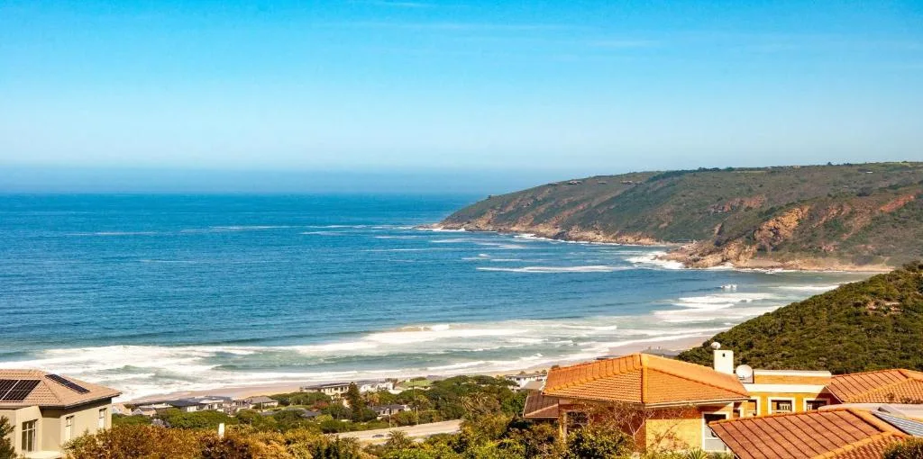 Panoramic coastal vista with golden beach, cliffs, and ocean horizon