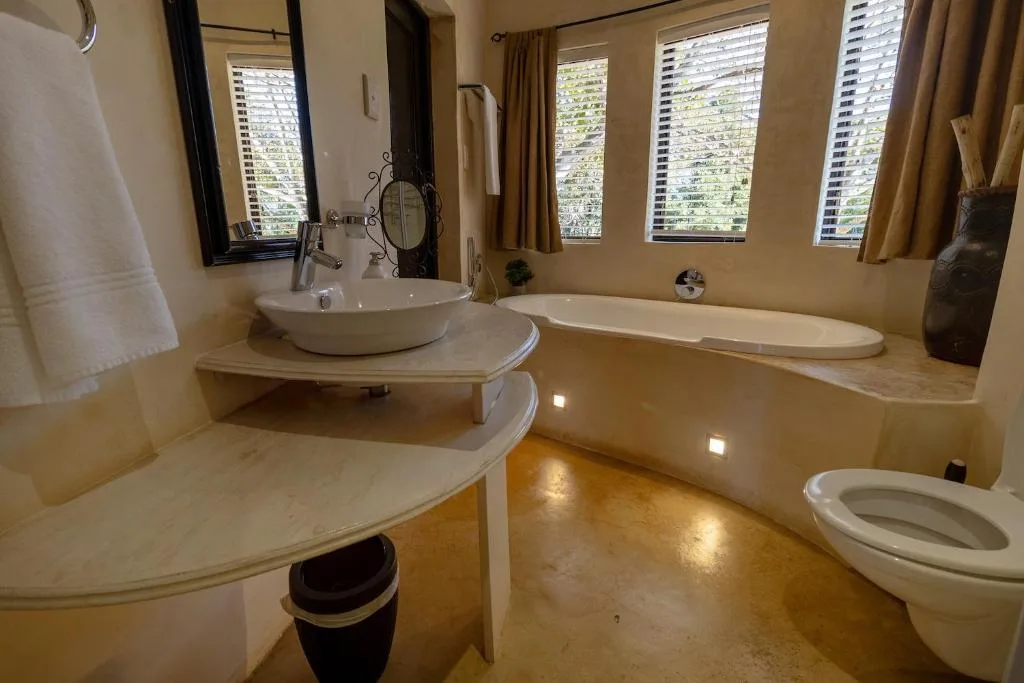 Spacious bathroom with vessel sink, soaking tub, and polished concrete floors