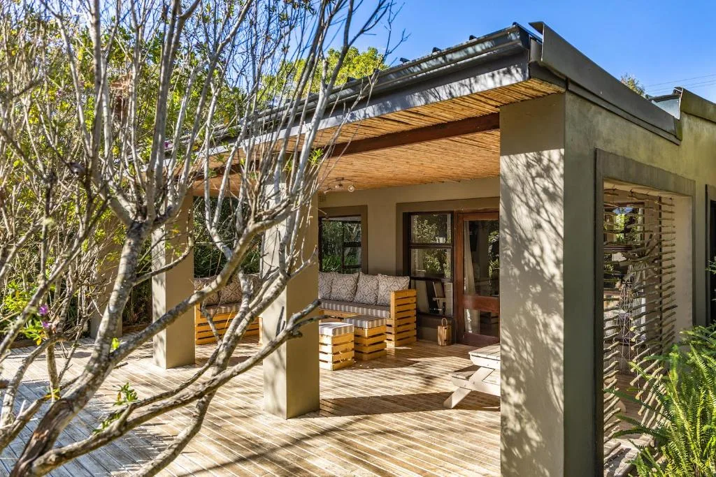 Wooden deck with modern pergola, seating areas, and native vegetation