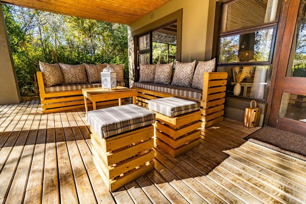 Wooden deck with handcrafted seating and cushions overlooking garden trees